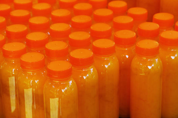 istock Many plastic bottles of fresh orange juice 1249595807