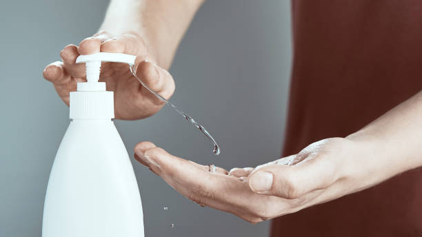 istock Male hands using hand sanitizer gel pump dispenser. 1249600452