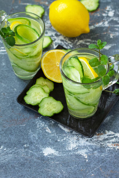 istock Fresh Cold and refreshing detox water with lemon and cucumber on a stone table. Copy space. 1249602807