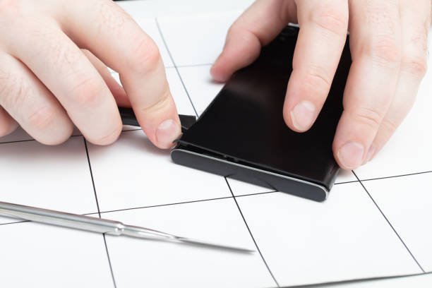 istock Replacing faulty modules in a mobile phone. The wizard opens the cover of the smartphone using special tools 1249603080