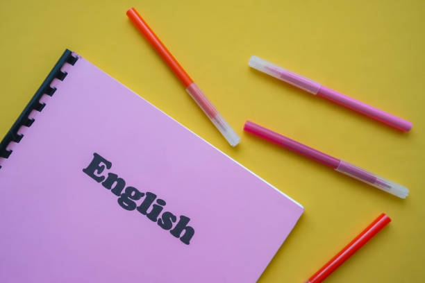 istock English language workbook with pencils on yellow background. school concept. first September. back to school. 1249603840