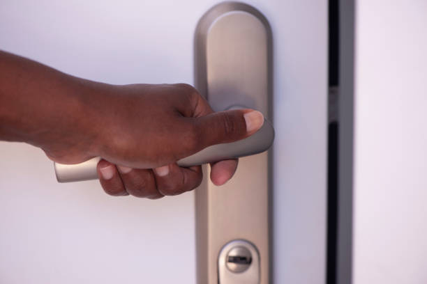 istock Opening / closing door. A woman's hand touching a metallic door handle. 1249604131