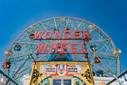 amusement park. ferris wheel made of white metal. on the wheel are large cabins for skiing tourists. huge structure made of metal rods.