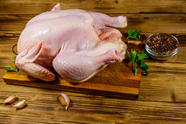 istock Raw whole chicken with spices on a wooden table 1249609624