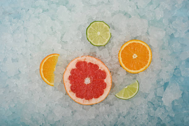 砕いた氷の上に新鮮な柑橘類のフルーツスライス - crushed ice colors grape fruit ストックフォトと画像