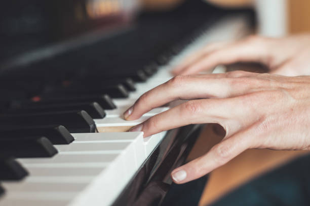 istock Playing piano at home, high angle view, blurry background. 1249614104