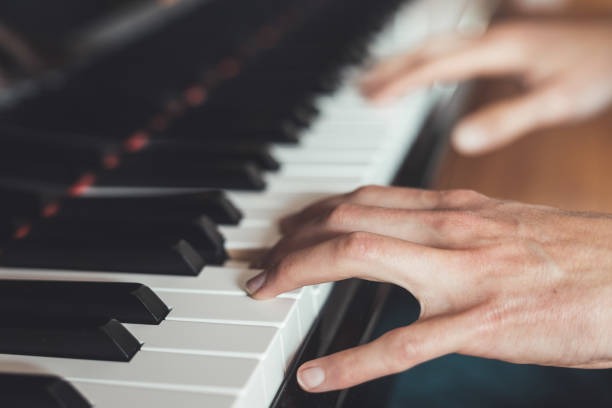 istock Playing piano at home, high angle view, blurry background. 1249614109
