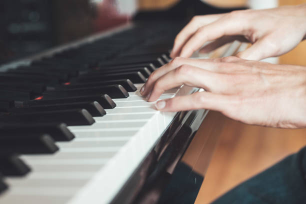 istock Playing piano at home, high angle view, blurry background. 1249614117