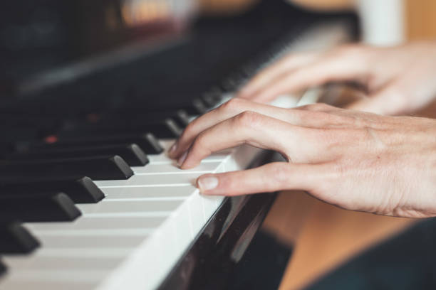 istock Playing piano at home, high angle view, blurry background. 1249614118
