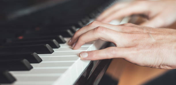 istock Playing piano at home, high angle view, blurry background. 1249614120