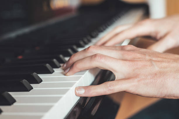 istock Playing piano at home, high angle view, blurry background. 1249614127