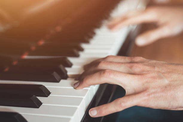 istock Playing piano at home, high angle view, blurry background. 1249614156