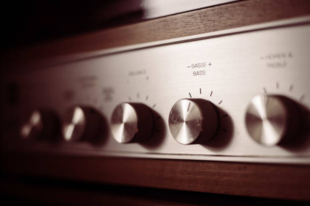 istock Silver wooden vintage amplifier: Close up of control knobs 1249614174