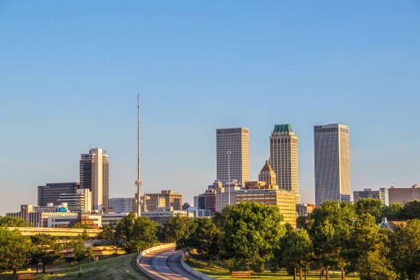Tulsa USA - View of downtown skyline from east in early morning with sun reflecting off historical art deco and modern buildings stock photo