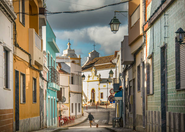 Street View of Alvor, Portugal Street view of the coastal town of Alvor in the Algarve, Portugal.  A man running with his dog down the street alvor stock pictures, royalty-free photos & images