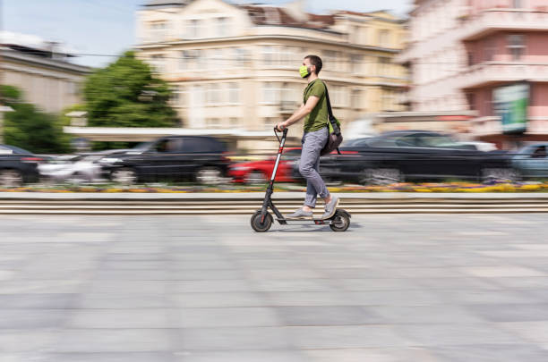 istock Young man riding e-scooter in the city 1249617672