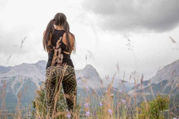 istock Young woman dances in grassy meadow 1249618631