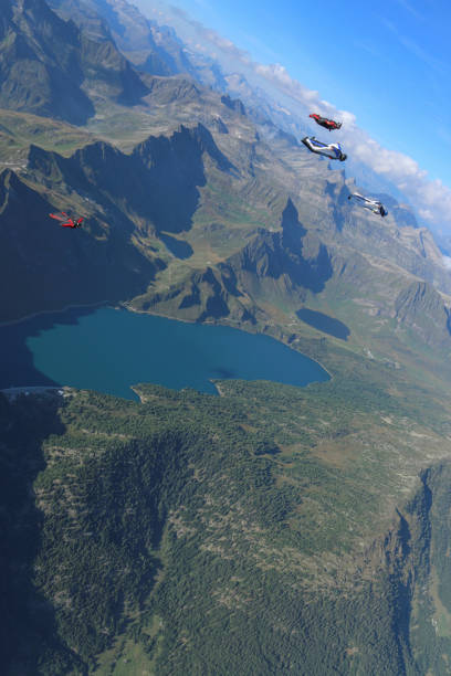 istock Wing suit fliers glide through blue skies in unison 1249618851