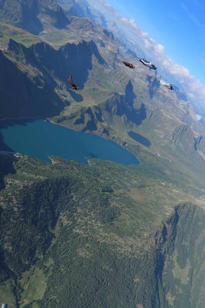 istock Wing suit fliers glide through blue skies in unison 1249618933