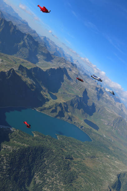 istock Wing suit fliers glide through blue skies in unison 1249618977