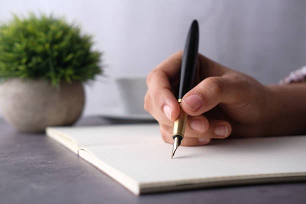 istock Close up of women hand with pen writing on a diary 1249620422