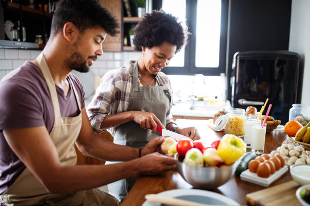 istock Beautiful young couple having fun and laughing while cooking in kitchen 1249622208