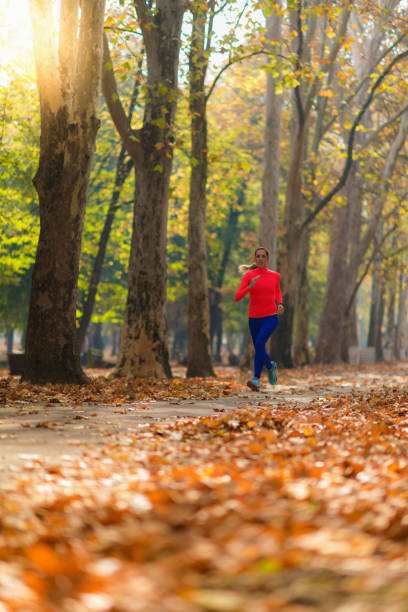 istock Woman Jogging Outdoors in Park 1249622972