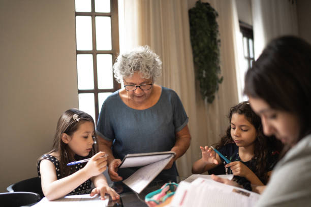 istock Grandmother helping granddaughter with homework while they studying at home 1249624307