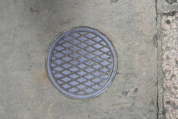 istock round manhole cover witj a diamond pattern on the sidewalk 1249624309