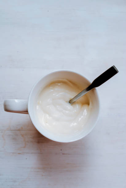 istock White yogurt in a white cup on a light background. 1249625978