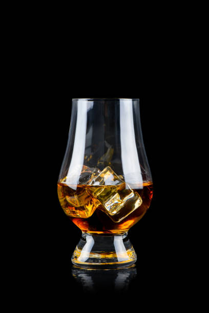 istock Glass of whiskey with cube ice on black background 1249626144
