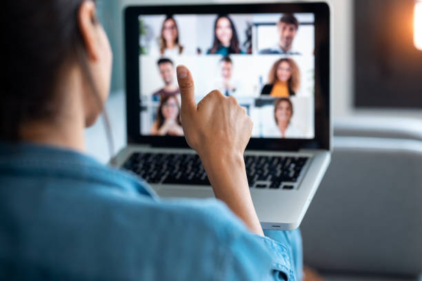 geschäftsfrau, die videoanruf und zeigen daumen bis zum laptop auf dem online-briefing, während sitzen auf dem sofa zu hause. - internet konferenz stock-fotos und bilder