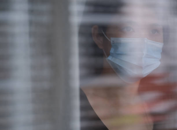 istock sad woman alone with surgical mask 1249627525