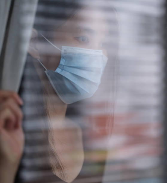 istock sad woman alone with surgical mask 1249627531