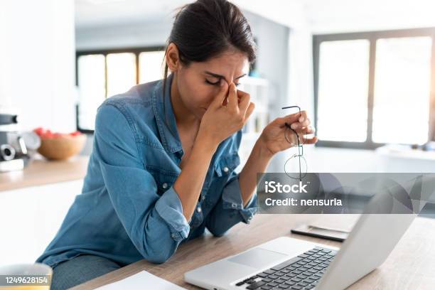 Stressed Business Woman Working From Home On Laptop Looking Worried Tired And Overwhelmed Stock Photo - Download Image Now