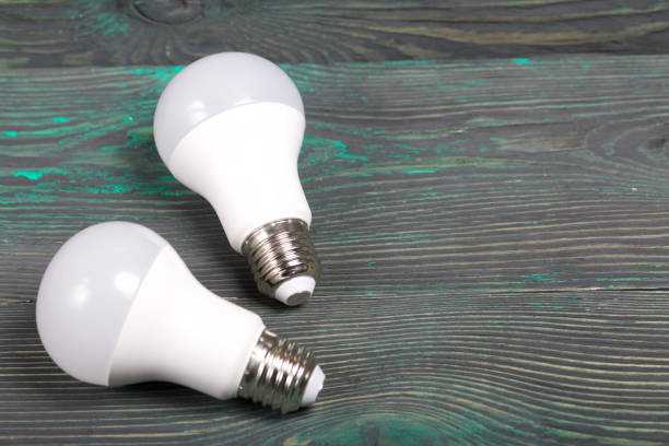 istock LED bulbs on pine boards painted in black and green. Green technology. 1249628290