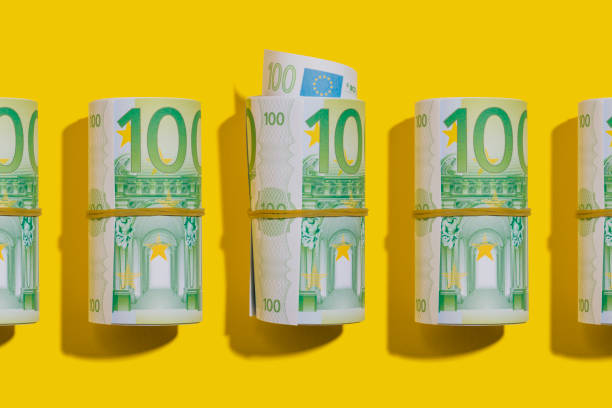 ユーロロールフラットは黄色の背景に横たわって - european union currency order finance currency ストックフォトと画像