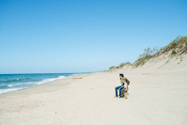 istock Little boy and his father relaxing on the beach 1249631290