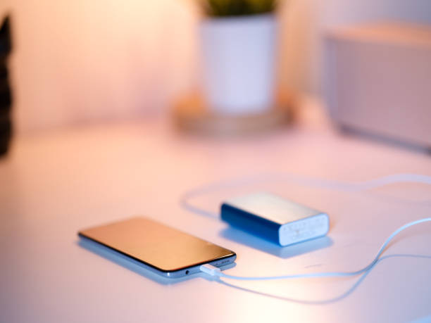 istock Smart Phone Charging with Blue Powerbank with White Background 1249631371