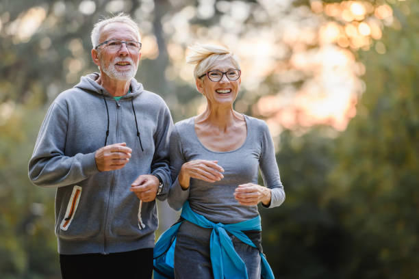 istock Smiling senior couple jogging in the park 1249632790