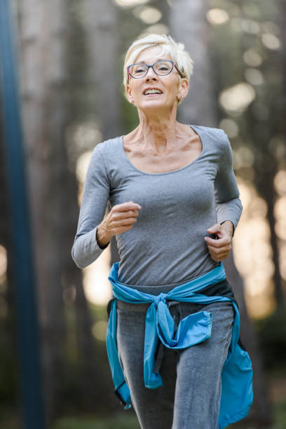 istock Smiling elderly woman jogging outdoors in the nature. 1249632906