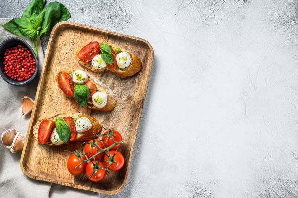 istock sandwiches with tomatoes, mozzarella cheese and basil. italian appetizer, antipasto. gray background. top view. Copy space 1249632948