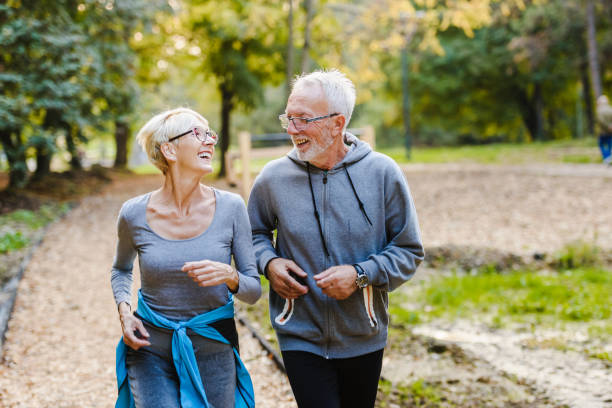 istock Smiling senior couple jogging in the park 1249633014