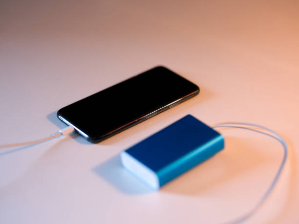 istock Smart Phone Charging with Blue Powerbank with White Background 1249633031