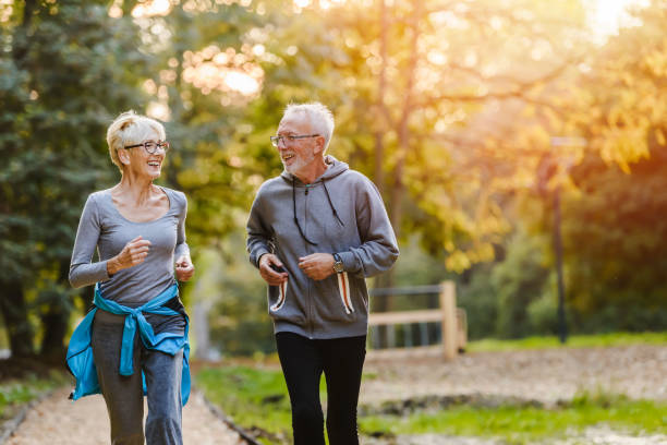 istock Smiling senior couple jogging in the park 1249633162