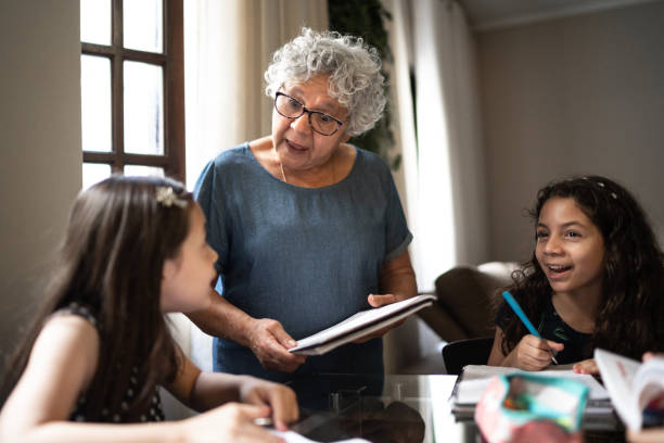 istock Grandmother helping granddaughter with homework while they studying at home 1249636444