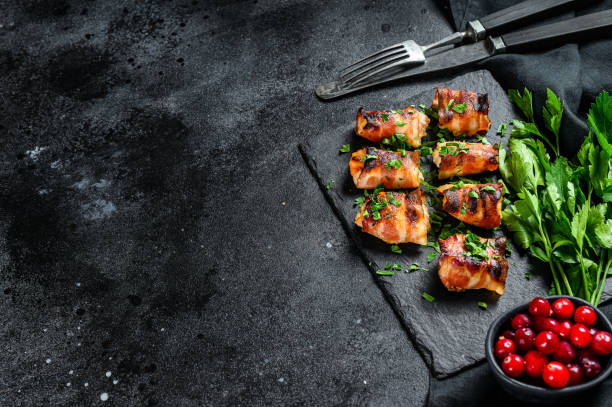 istock Baked bacon wrapped chicken breast. Black background. Top view. Copy space 1249637894
