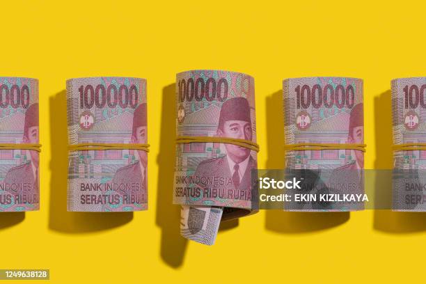 Indonesian Rupiah Rolls Flat Lay On Yellow Background Stock Photo - Download Image Now