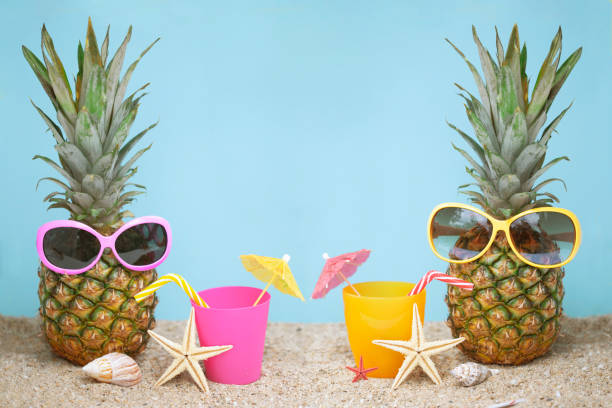 Pineapple on sea sand with blue background. Summer background.
