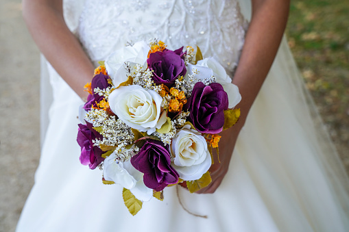 bride holding a purple and white wedding bouquet of flowers. Bride with wedding bouquet